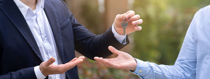 Seller of home gives keys to buyer of home