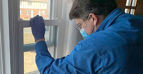 Elmira home inspector Paul Peck is inspecting a window sash to see if it opens and closes properly in a house located in Horseheads NY